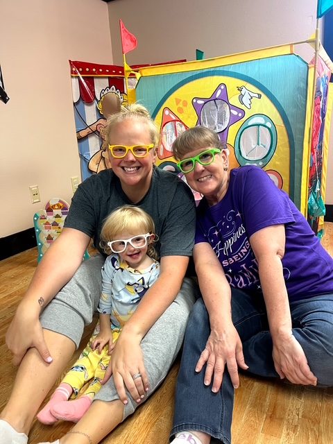 Three generations in matching play glasses at Grammy's Town
