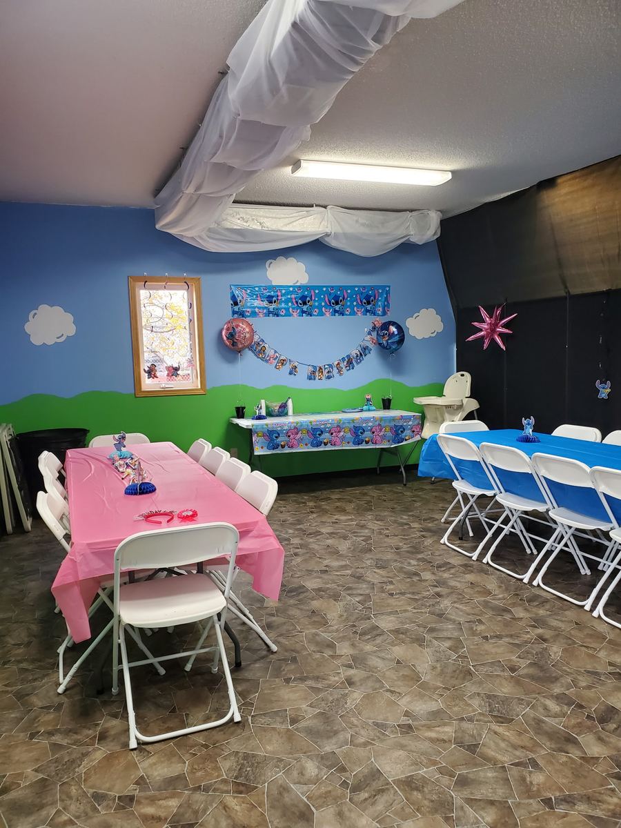 Party room with pink and blue tables and character decorations