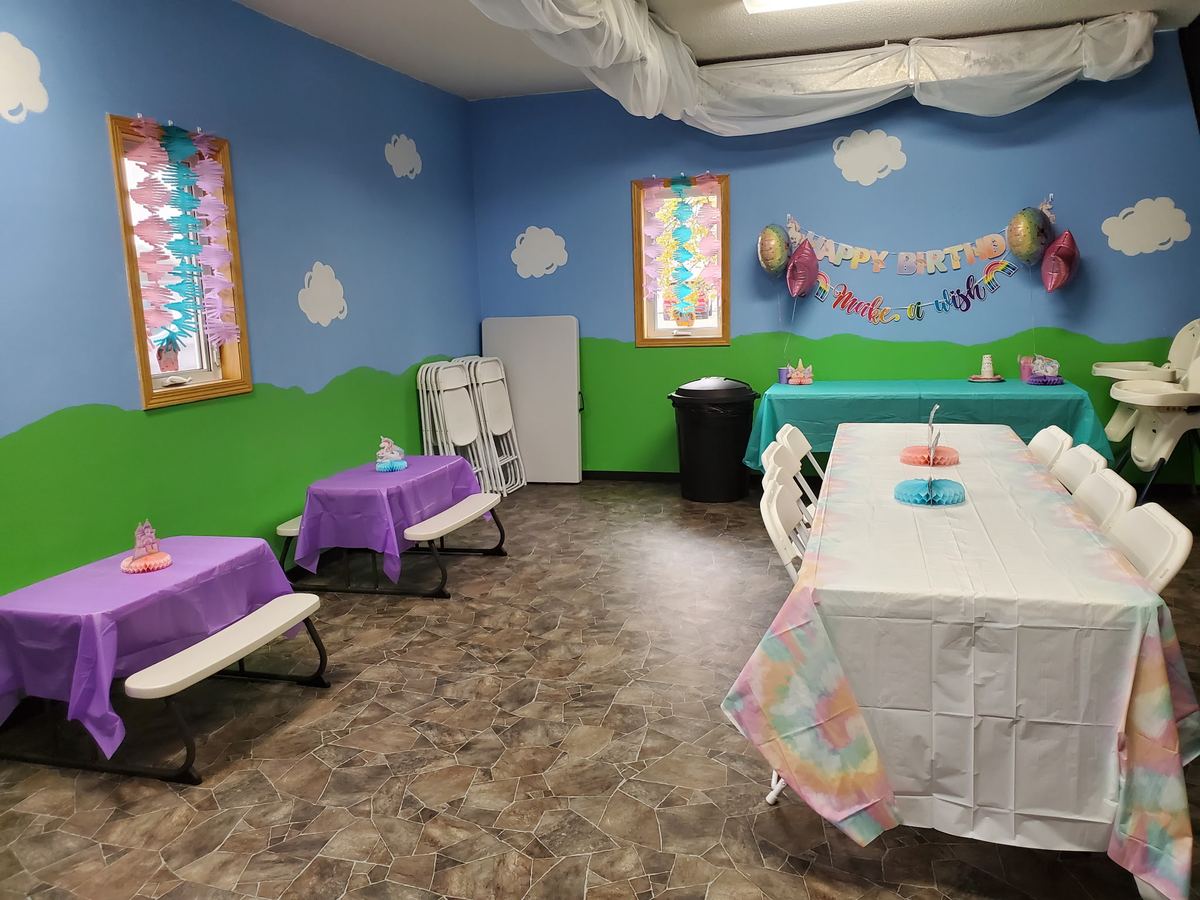 Unicorn-themed party with pastel tablecloths and kid-size picnic tables
